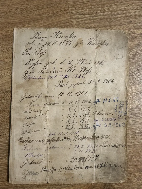 A worn handwritten family record in old German script listing births, a marriage and deaths between 1877 and 1927, with later annotations