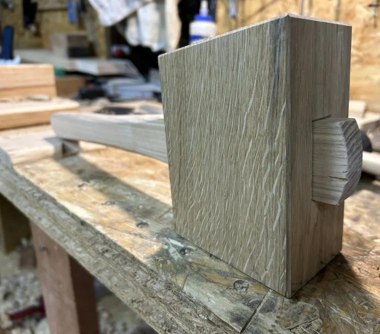 A hand-made joiner&rsquo;s mallet with an oak head and a wedged ash handle, resting on a workbench